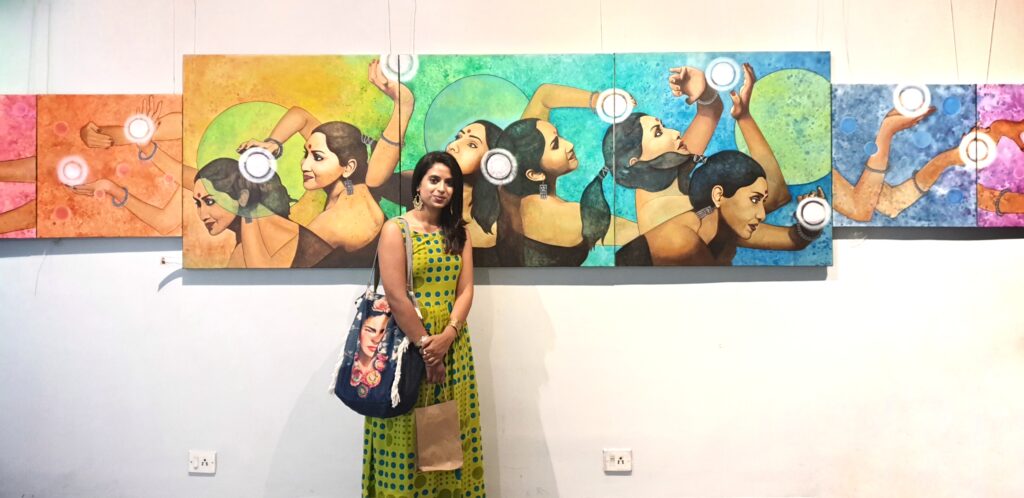 Mona KV standing in front of her artwork, Past, Present & Future.